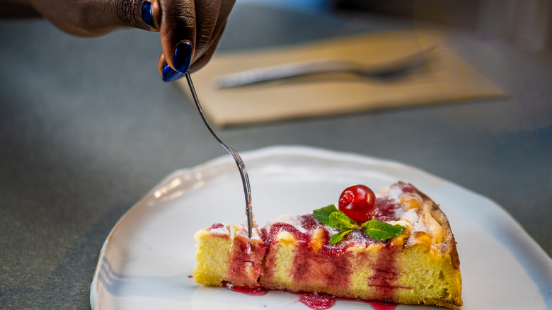 fork cutting into cheesecake