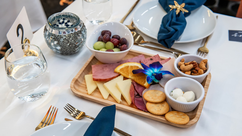 An appetizer plate featuring meat and cheese at a wedding table.
