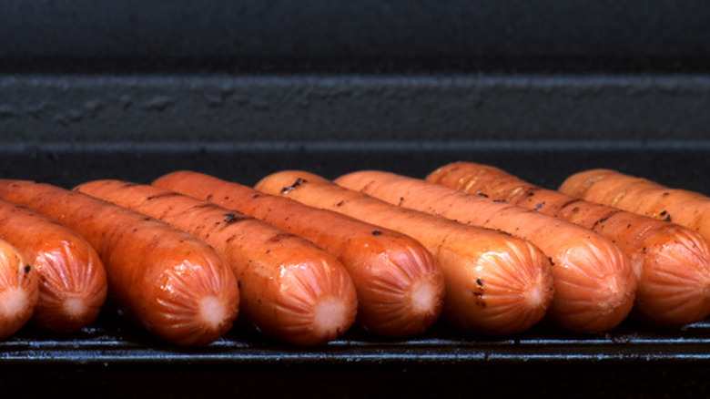 Hot dogs on black grill