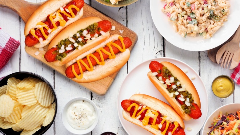 Hot dogs and assorted sides on a wooden backdrop