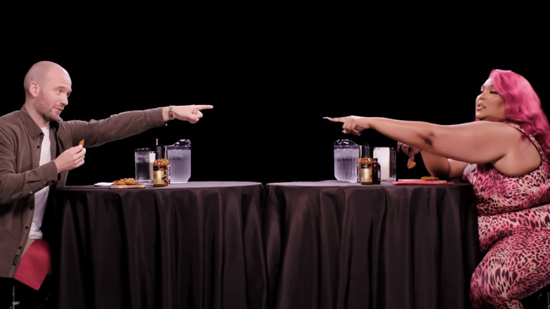 Sean Evans and Lizzo pointing at each other on Hot Ones