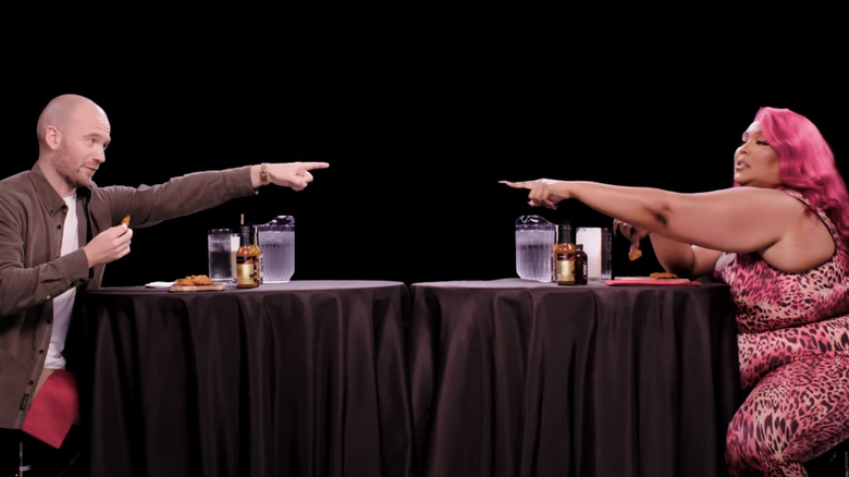 Sean Evans and Lizzo pointing at each other on Hot Ones