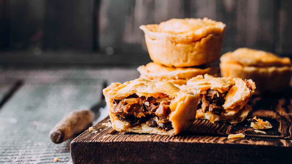 meat pies sitting on cutting board