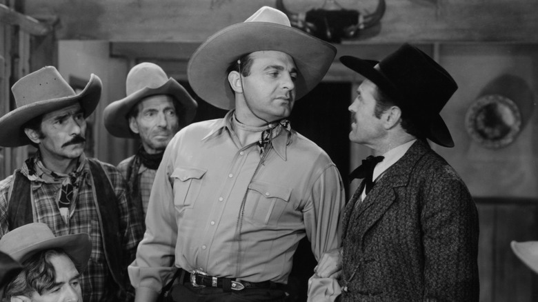 Actor Ray Corrigan with others on a Western set.