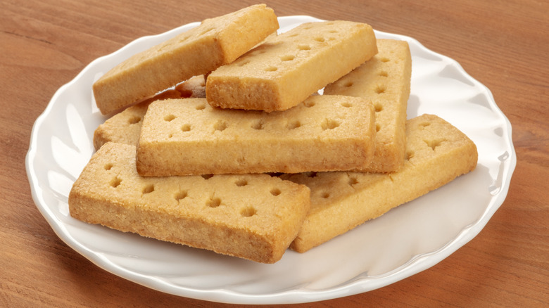 Stack of rectangular shortbread cookies on white plate.