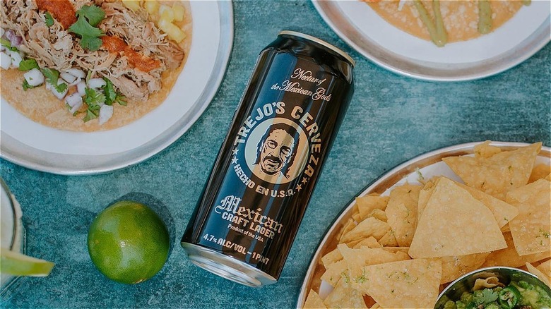 can of trejo's cerveza with food from trejo's tacos