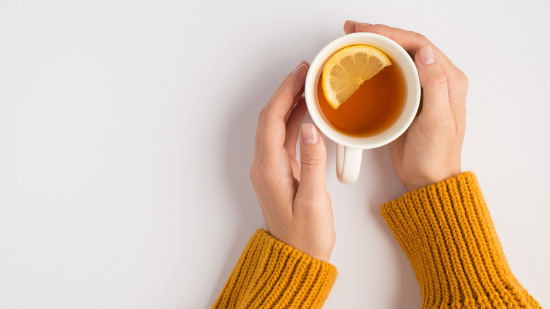 A woman's hand wrapped around a mug of tea