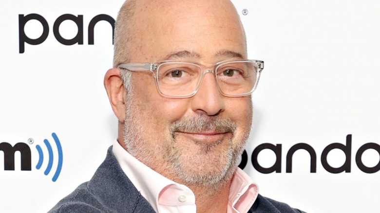 Andrew Zimmern smiling in glasses