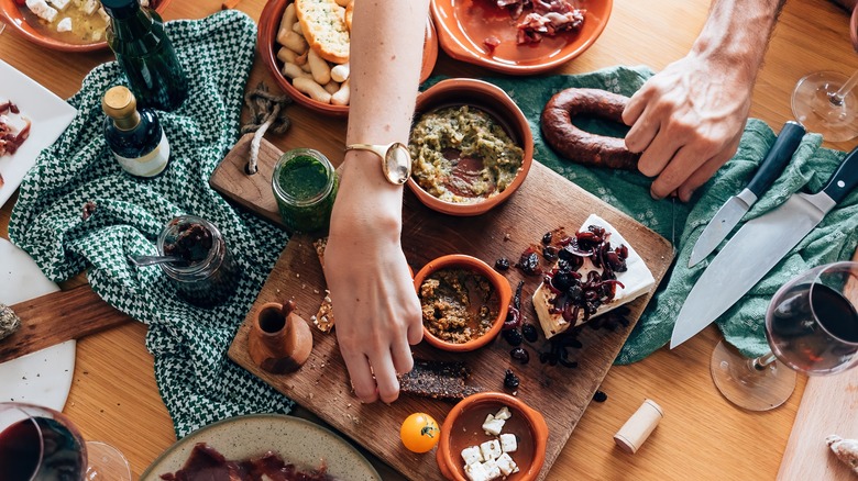 flay lay of appetizers on table, people reaching for food