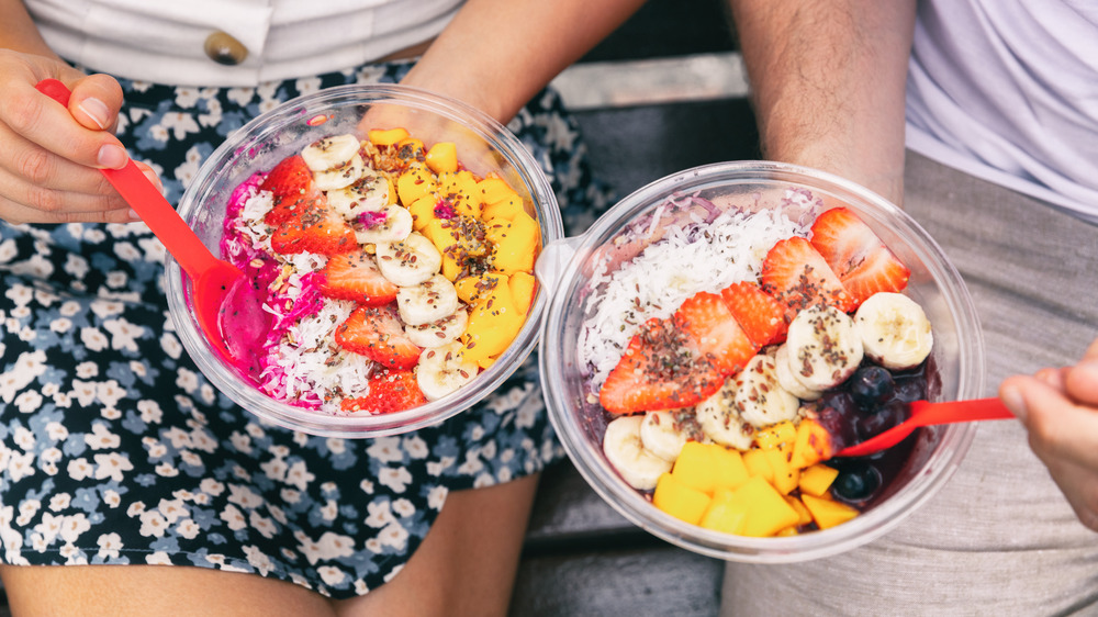 two smoothie bowls with fruit, coconut, and chia seeds