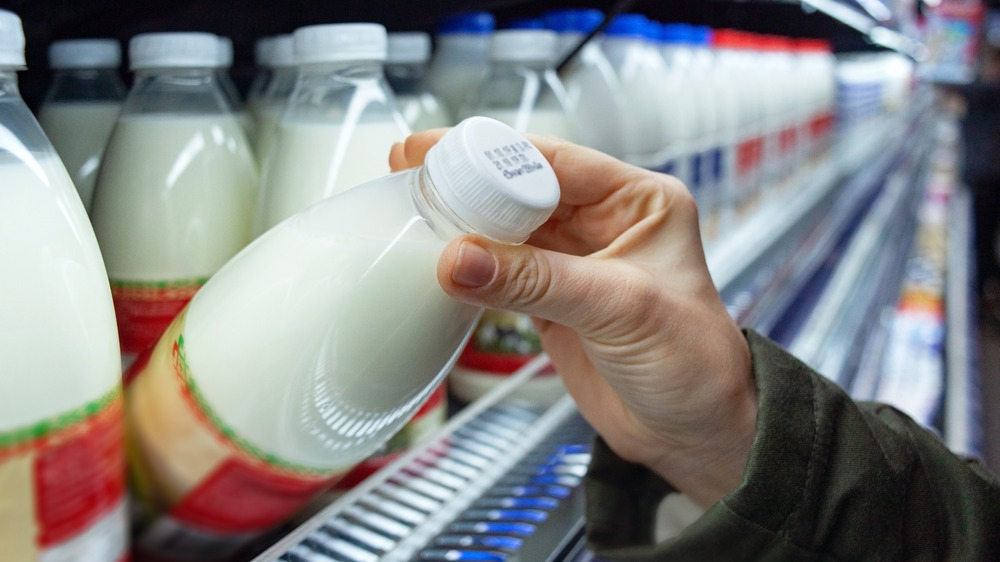 Checking expiration date on bottle of milk