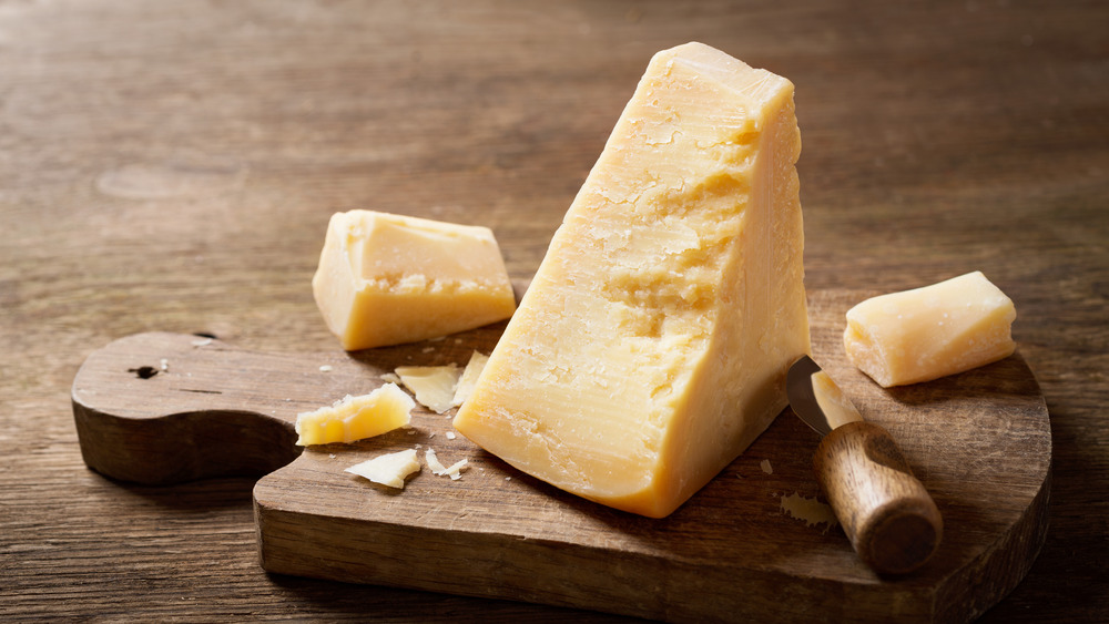 Wedge of Parmesan cheese on wooden board