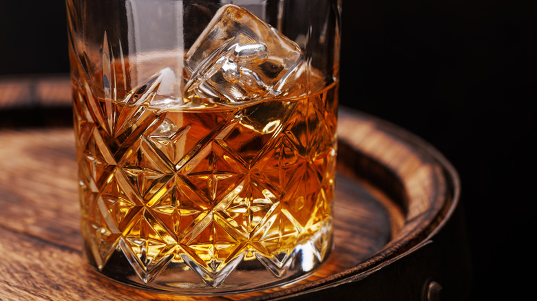 Whiskey glass on a wood barrel