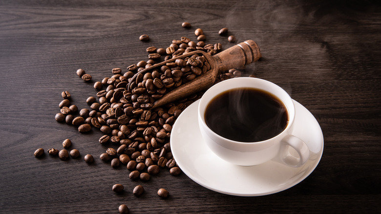 Hot coffee with beans on table