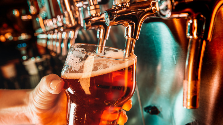 Person pouring a brown beer