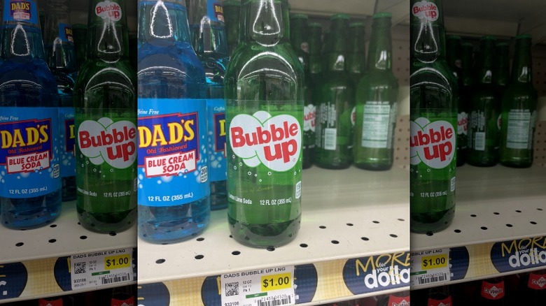 Plastic bottles of Bubble Up and Dad's Blue Cream soda on store shelf