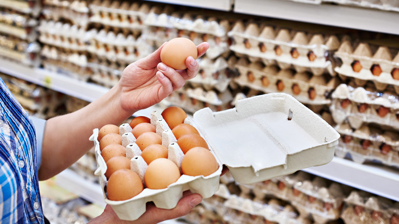 A person buying eggs at grocery store