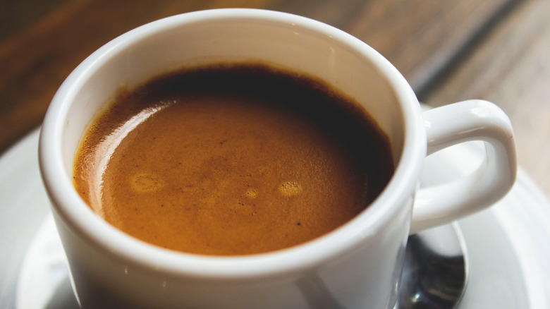 A close up of an espresso white cup with cuban coffee 