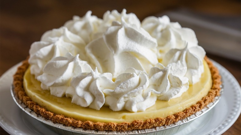 Whole key lime pie topped with whipped cream