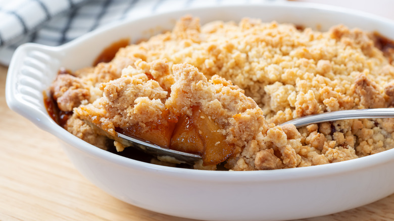 Spoonful taken out of dish of apple crisp