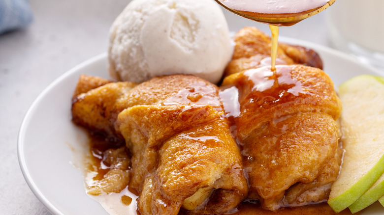 Two apple dumplings on plate with sauce