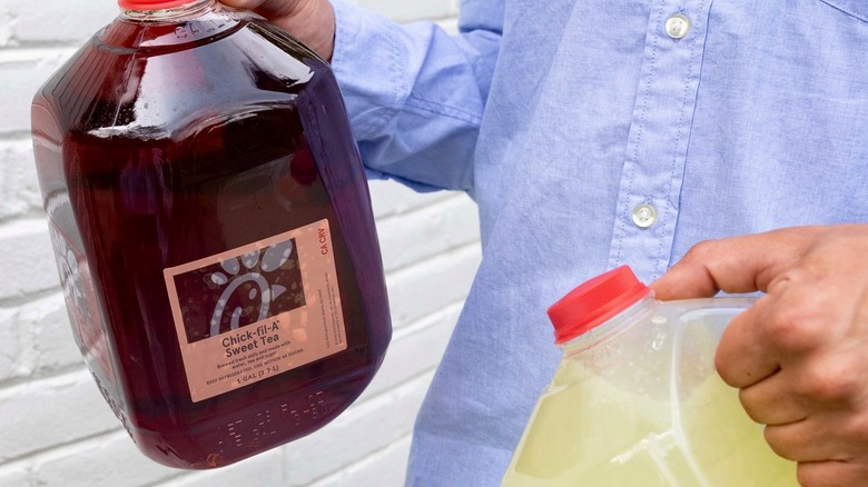 Person holding gallons of Chick-fil-A tea and lemonade