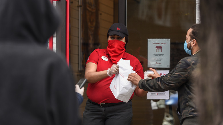 A Chick-fil-A employee handing over an order 