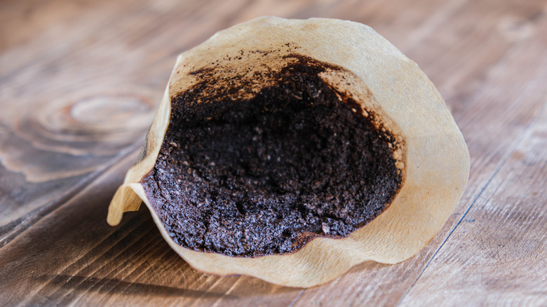 Used coffee grounds in a filter on a table