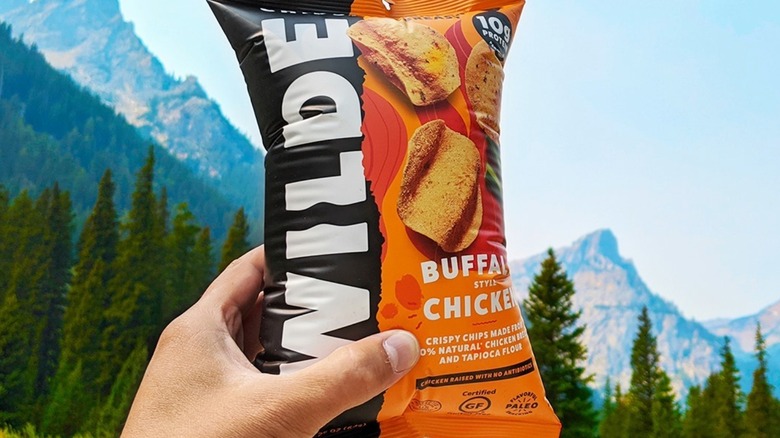 Hand holding bag of Wilde Buffalo chicken chips