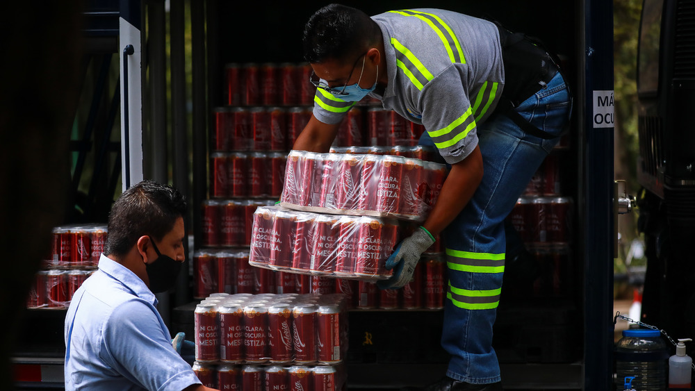 Delivery people dropping off stacks of beer
