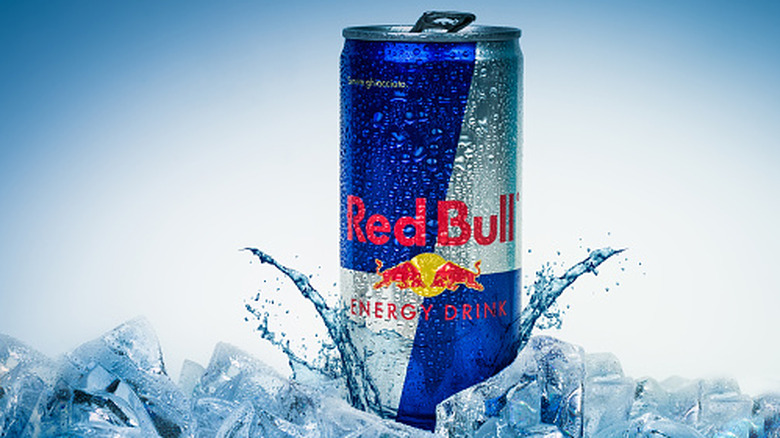 Red Bull can splashing into ice water