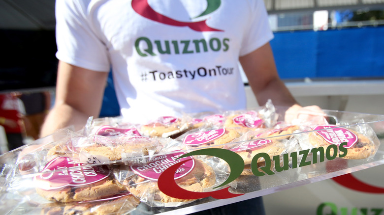 Quiznos employee carrying cookie tray