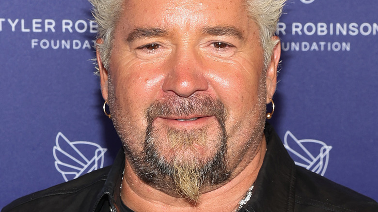 Guy Fieri with slight smile and earrings