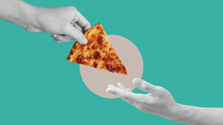Grey hand passing slice of pizza to another hand