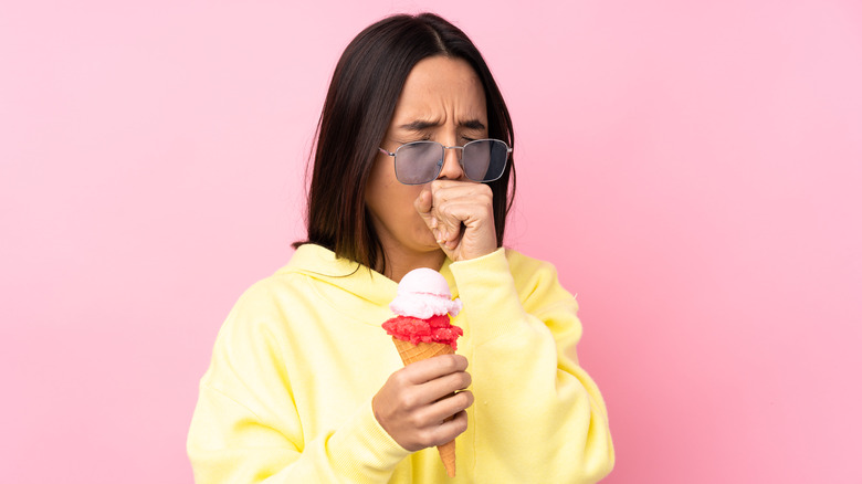 woman sneezing while eating ice cream
