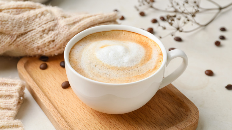 cappuccino in white mug on wooden board