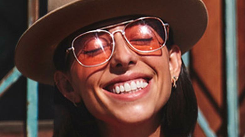 Jade Catta-Preta smiling on steps in hat