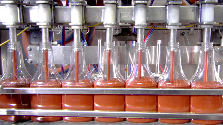 Machine pumping ketchup into bottles