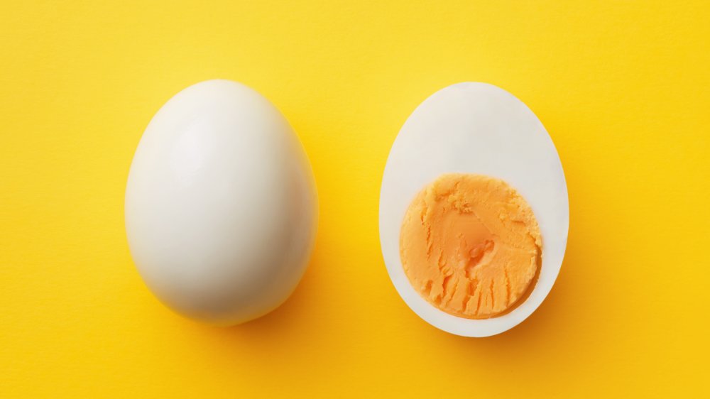 Hard-boiled egg cut in half on a yellow background