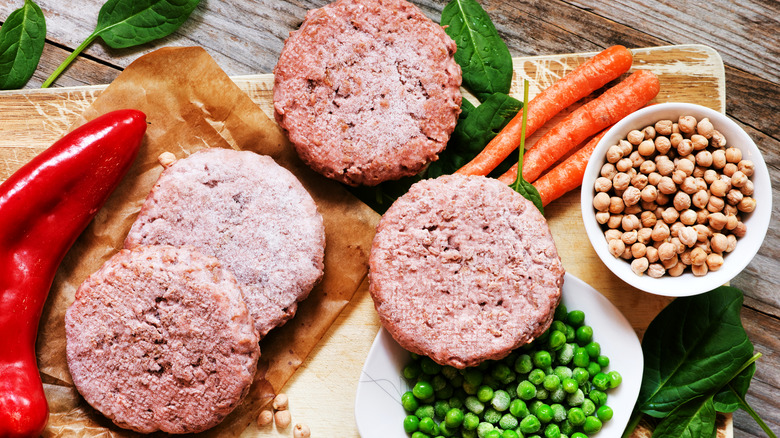 Frozen burger patties on cutting board