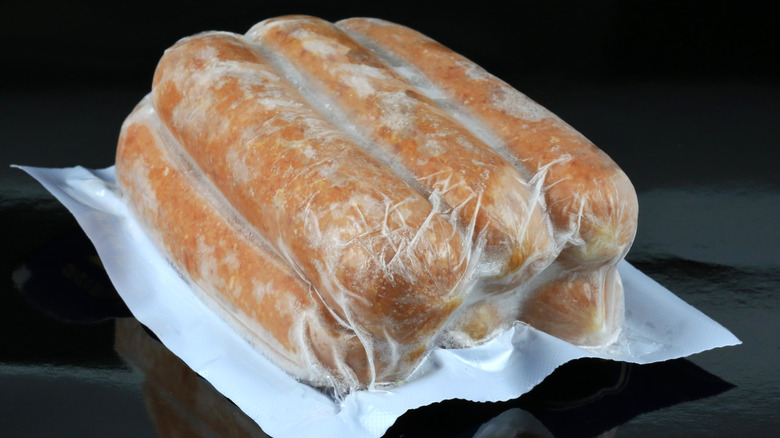Pack of frozen hot dogs on black table