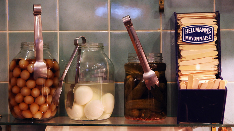 Pickled eggs and other snacks on shelf in London pub