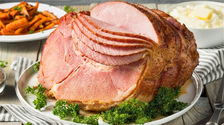 spiral ham on table with carrots and mashed potatoes