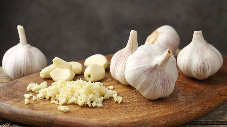 Garlic heads, cloves, and minced garlic on cutting board