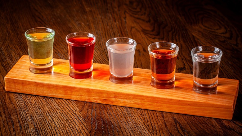 Assorted types of alcoholic beverages in shot glasses.
