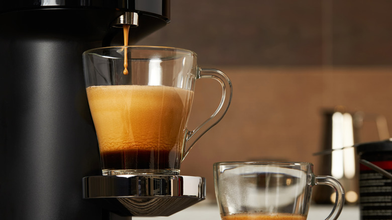 Espresso machine dispensing shot into glass cup.