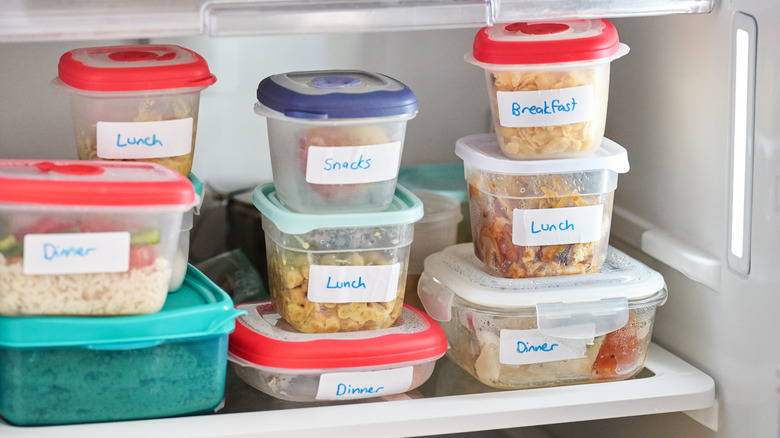 Labeled containers of leftovers in refrigerator.