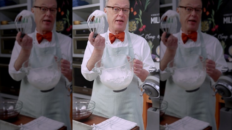 Christopher Kimball holding a whisk and bowl of whipped egg whites