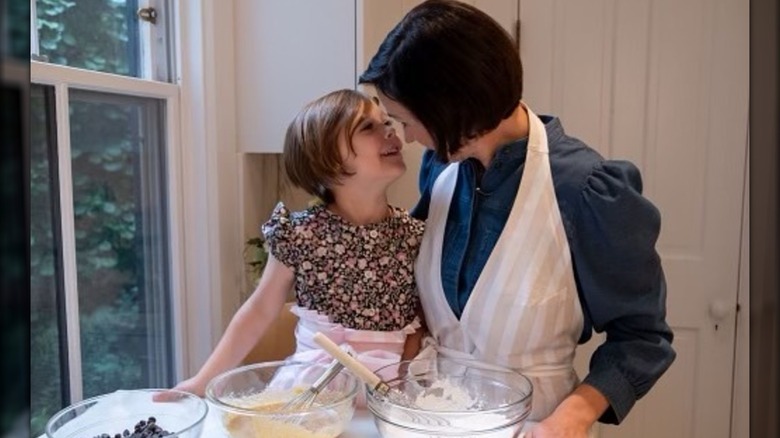 Melissa Baldino and her daughter, Rike, smiling at each other while baking