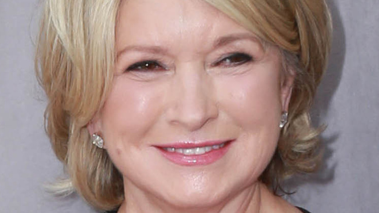 Martha Stewart smiles with pink lipstick and diamond earrings